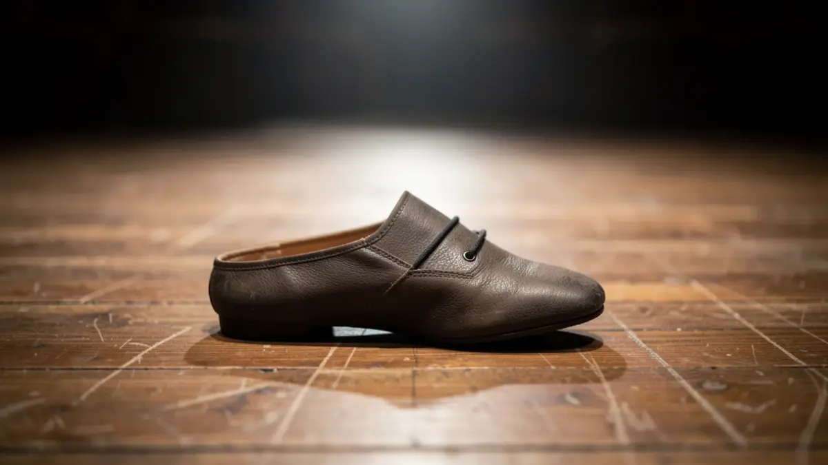 Generic image of a dance shoe on a stage floor.